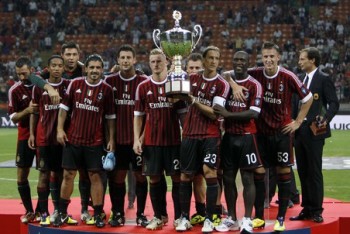 AC Milan captain Massimo Ambrosini holds the trophy with his team mates after defeating Juventus in their Berlusconi Trophy soccer match at the San Siro Stadium in Milan